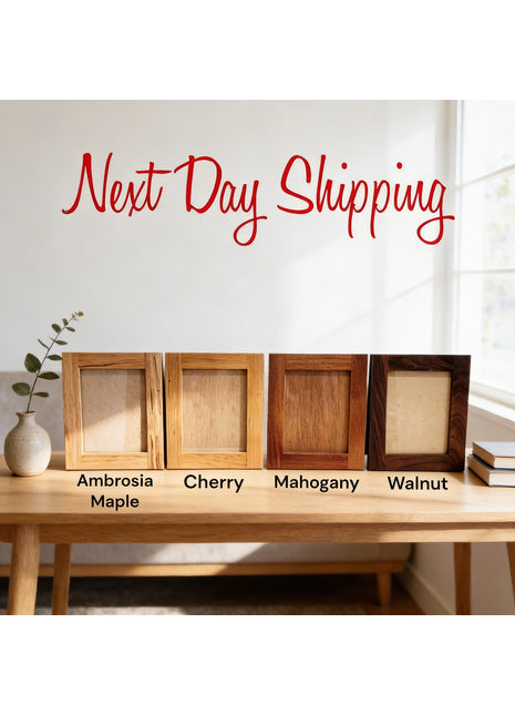 four different types of wooden picture frames arranged on a wooden table, with a vase of greenery and a window in the background.