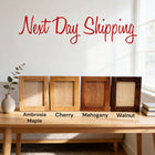 four different types of wooden picture frames arranged on a wooden table, with a vase of greenery and a window in the background.