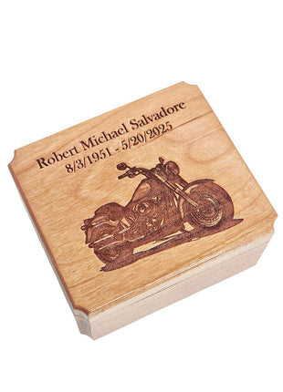 A wooden box with a carved image of a motorcycle on it, and the text "Robert Michael Salvadore 8/3/1951 - 5/30/1925" engraved on it.