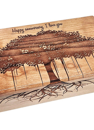 A wooden box with a tree design and the text "Happy anniversary I love you" engraved on it.