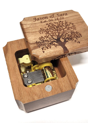 a wooden music box with a tree engraved on it