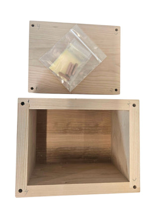 a wooden box with a clear plastic bag containing small wooden pieces, placed on top of the box.
