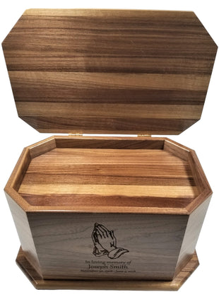 a wooden box with a praying hands on it