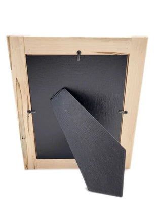 a wooden frame with a black background inside, and a black triangular object attached to the right side of the frame.