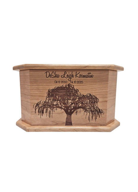 A wooden box with a tree engraved on it, featuring the text "DeSha Leigh Kosmatin" and the date "Oct 12 2000 - 10 10 2005".