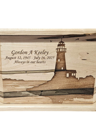 a wooden box with a lighthouse design, and there is a memorial inscription on it.