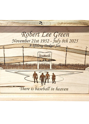 The image is a wooden memorial box with a design that includes a baseball field, three people, and a message about Robert Lee Green.
