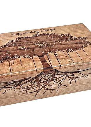A wooden box with a tree design on the lid, featuring a tree with roots and branches.