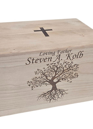 A wooden box with a tree design and a cross on top, along with the text " Loving Father Steven A. Kolb" engraved on it.